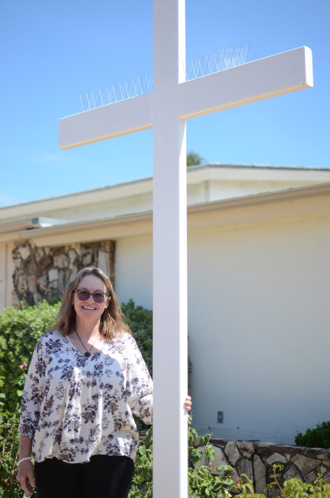 Amber Tunes, standing in front of a white cross.