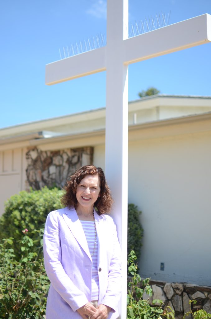 Holly Churchman, standing in front of a white cross.