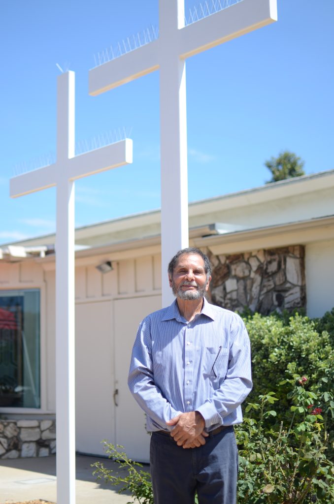 Oscar Duran, standing in front of a white cross.