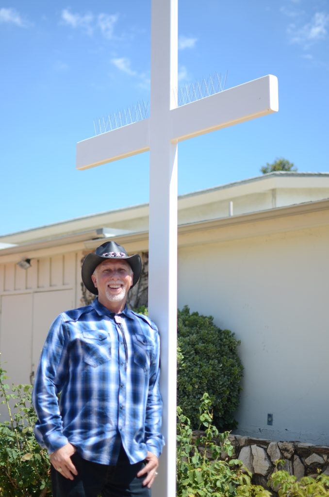 Robert Churchman, standing in front of a white cross.