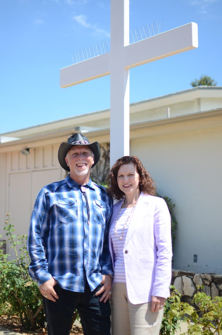 Robert and Holly Churchman, standing in front of a white cross.